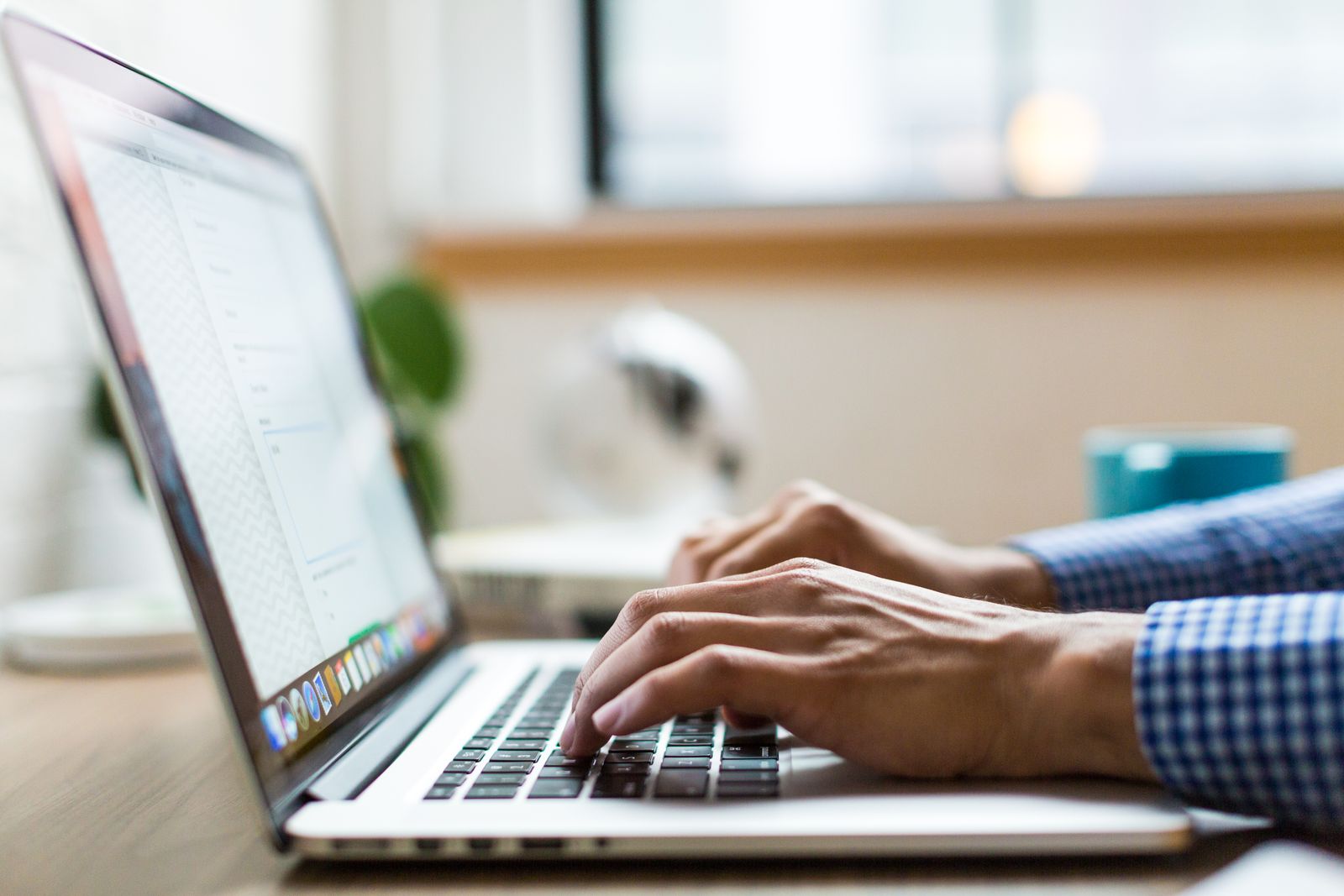 A person reading email on a laptop at a desk